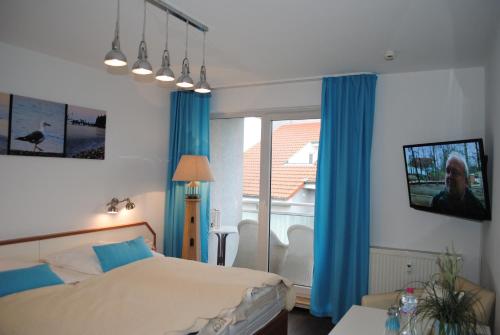 Schlafzimmer mit einem Bett, einem TV und einem Fenster in der Unterkunft Ferienwohnung Yachthafentraum in Kühlungsborn