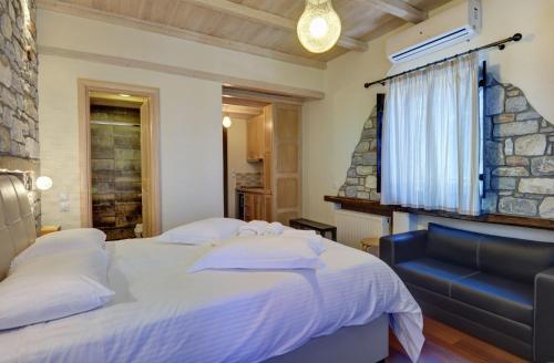 a bedroom with a large bed and a blue couch at Mple Feggari in Mouresi