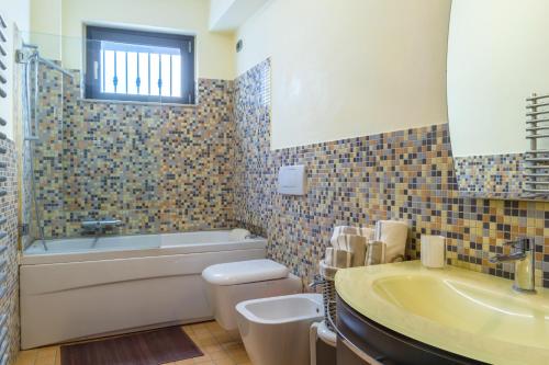 a bathroom with a tub and a toilet and a sink at Casa Lì in Giardini Naxos
