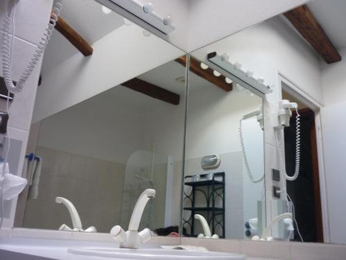 bagno con specchio e lavandino di Auberge de l'Aspre a Fontanges