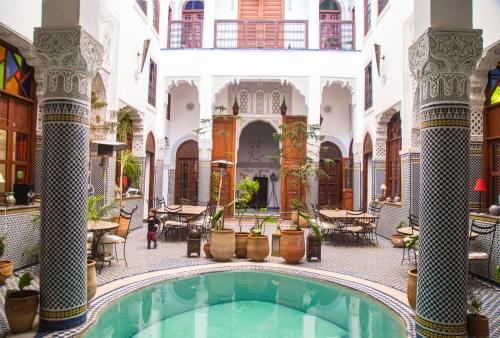 een binnentuin met een zwembad in een gebouw bij Riad Jamaï in Fès