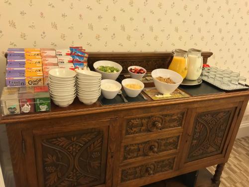 a table with bowls and plates on top at Crow How Country Guest House in Ambleside