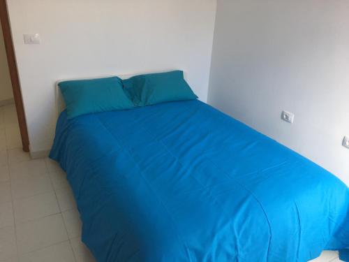 ロス・ジャノス・デ・アリダネにあるMinipisoの白いベッドルームの大きな青いベッド