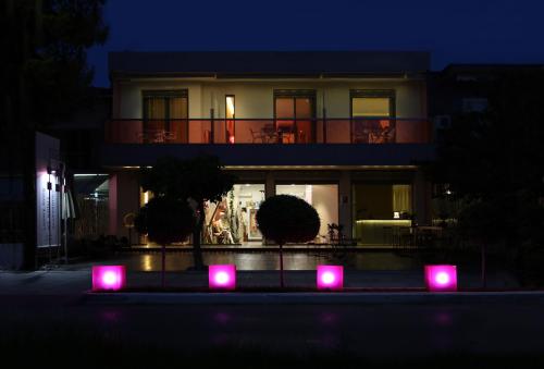 a house with pink lights in front of it at night at island in Pefki