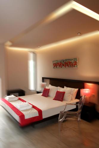 a bedroom with a large bed and a chair at island in Pefki