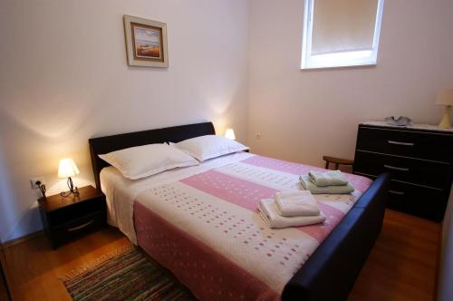 um quarto com uma cama com duas toalhas em Apartment Radunić em Kaštela