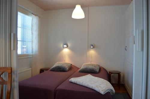 um quarto com uma cama com lençóis roxos e uma janela em Pointin Vale Apartment Tahko em Tahkovuori