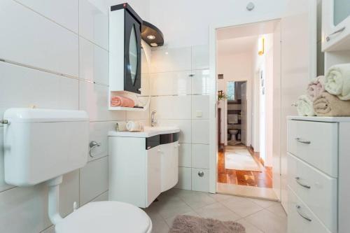 Un baño blanco con inodoro y lavabo. en Villa Aska, en Lopud Island