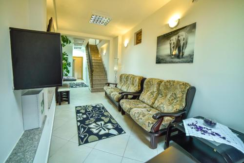 a living room with a couch and a flat screen tv at Hostel Sinj in Sinj