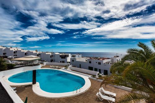 a swimming pool with a view of the ocean at Vivienda Vacacional Lizzy in Puerto del Carmen