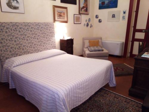 a bedroom with a bed and a chair at A casa di Tommy B&B in Acireale