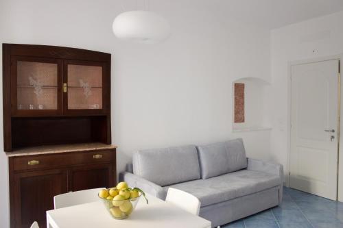 a living room with a couch and a table with a bowl of fruit at Cà dei Ciuà - Apartments for rent in Riomaggiore