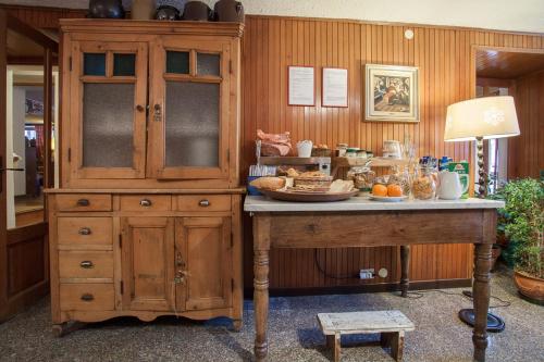 a large wooden cabinet in a room with a table at Hotel Funivia in Courmayeur