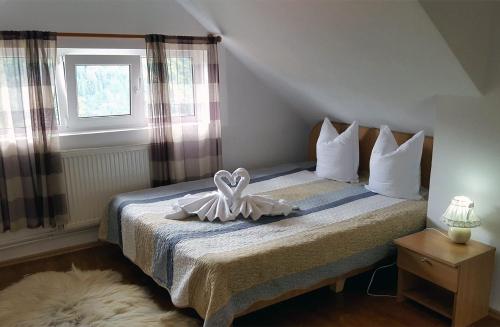 a bedroom with a bed with a bow on it at Pensiunea Vila Gabriel in Sinaia