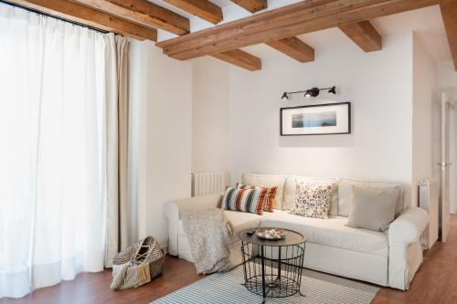 a living room with a white couch and a table at Casa de Mi Abuela Ribera del Duero in Roa