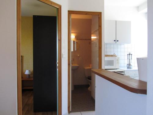 une cuisine avec une porte noire et un four micro-ondes dans l'établissement Appartements Cancale, à Cancale