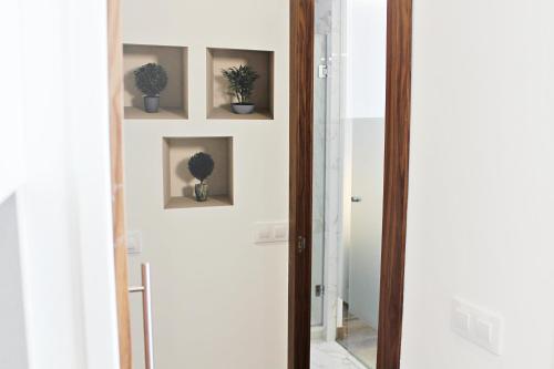 a hallway with a mirror and potted plants on the wall at Salamaca-Goya in Madrid