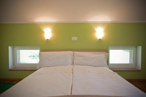 a bedroom with two windows and a bed with white sheets at Apartments Soča in Kobarid