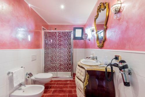 a bathroom with a sink and a toilet and a shower at Hotel Sa Cheya Relais & Spa in Alghero
