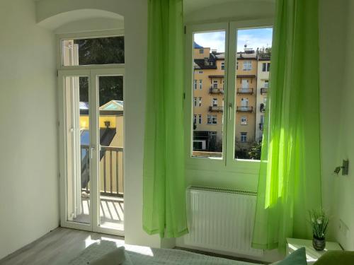 een kamer met groene gordijnen en uitzicht op een gebouw bij Iceman Room's Central in Bolzano