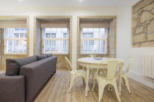 a living room with a couch and a table and chairs at OHH -S João apartments- Riverside in Porto