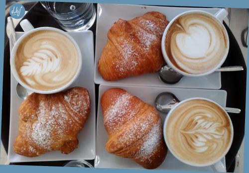 une assiette avec deux tasses de café et deux pâtisseries dans l'établissement Corte Trullo Sovrano B&B, à Alberobello