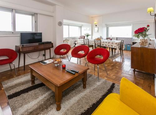 a living room with red chairs and a table at Apartamento Vintage 2 in Porto