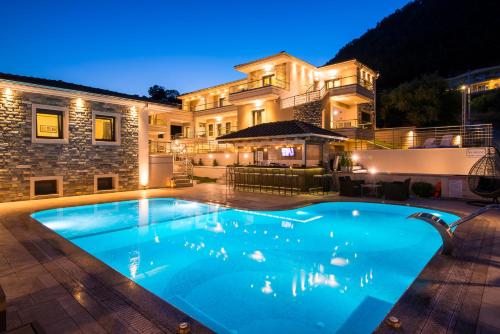 a swimming pool in front of a house at night at Semiramis Luxury Suites in Chrysi Ammoudia