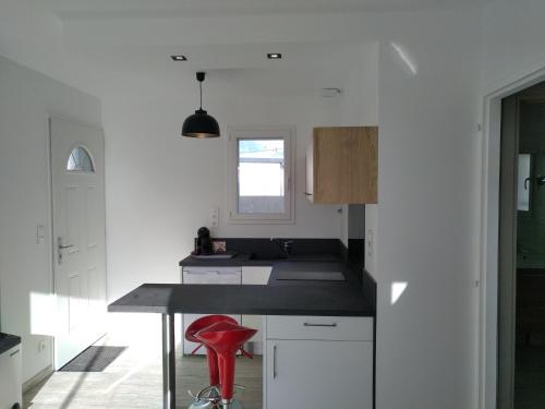 a kitchen with a counter and a red stool at Plaisance du Touch in Plaisance-du-Touch