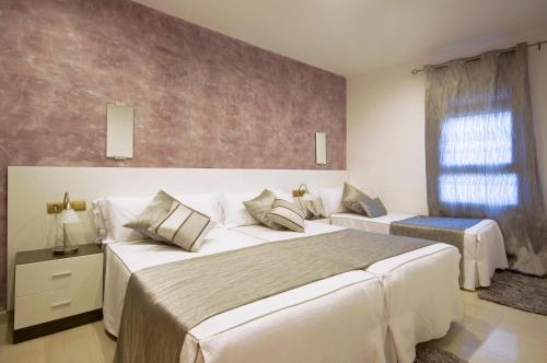 a bedroom with two beds and a window at Aparthotel Rambla108 in Barcelona