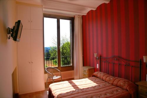 um quarto com uma cama e uma grande janela em Hostal La Fuente em Buera