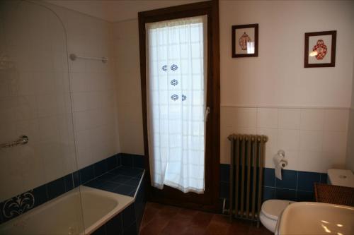baño con bañera, aseo y ventana en Hostal La Fuente en Buera