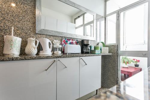 a kitchen with white cabinets and a window at Apartamento Vintage 2 in Porto