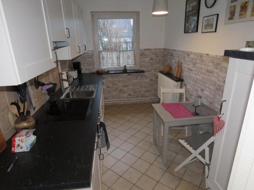 uma cozinha com um lavatório e uma mesa em Marigold em Neumünster