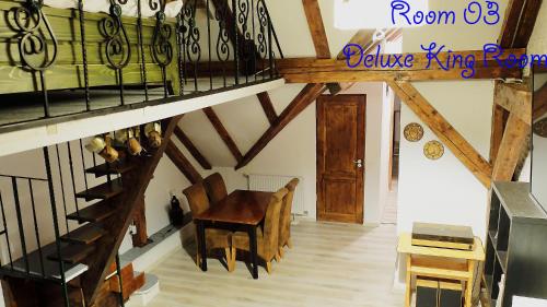 a room with a wooden table and a staircase at 4 Rooms Piata Sfatului in Braşov
