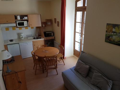 ein Wohnzimmer mit einem Tisch und einer Küche in der Unterkunft Aulus-les-Bains in Aulus-les-Bains