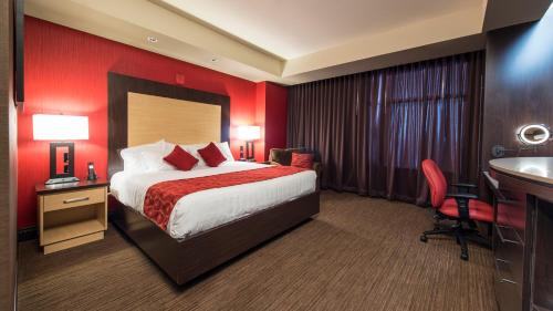 Habitación de hotel con cama, escritorio y lavabo. en Cherokee Casino Hotel Roland, en Roland