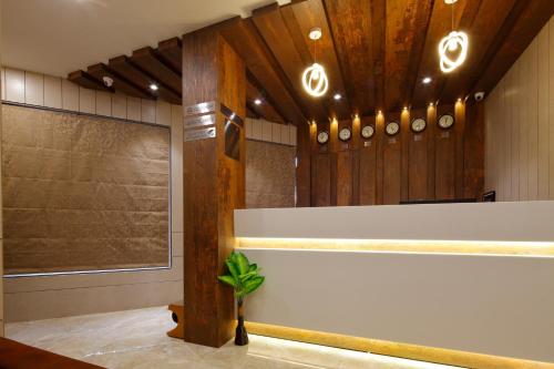 a lobby with a white counter and wooden walls at Hotel Alka Inn in Ahmedabad