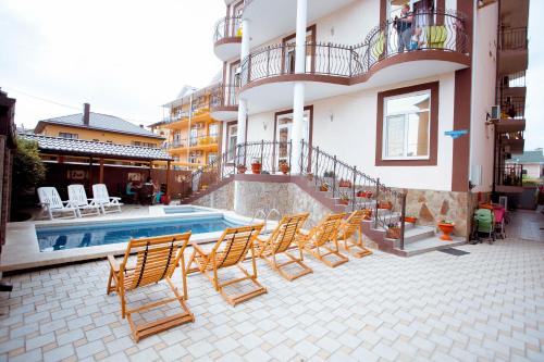 a group of chairs sitting next to a swimming pool at Отель КИПР Витязево in Vityazevo