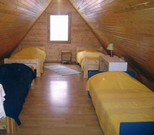 a attic room with three beds and a window at Zielony Domek Wisłoczek in Rymanów