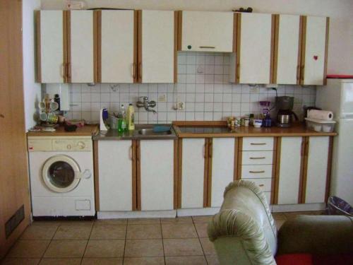 a kitchen with white cabinets and a washing machine at Zielony Domek Wisłoczek in Rymanów