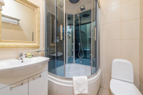 
a bathroom with a shower, toilet and sink at Grand Hotel Belorusskaya in Moscow

