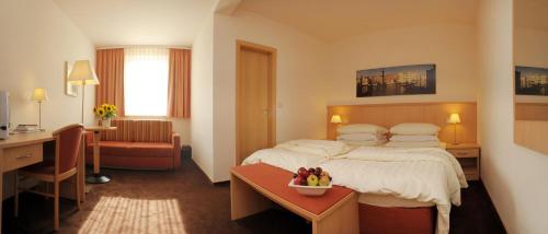 a hotel room with a bed and a desk at Lübsche Thorweide in Wismar