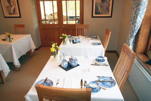 een eetkamer met een tafel met blauwe en witte gerechten bij West Acre House in Alnwick