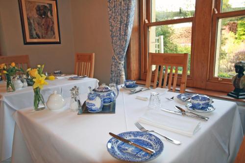 a dining room with two tables with blue and white dishes at West Acre House in Alnwick