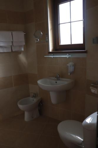 a bathroom with a sink and a toilet and a window at Roots Hotel and Wine Bar in Plovdiv