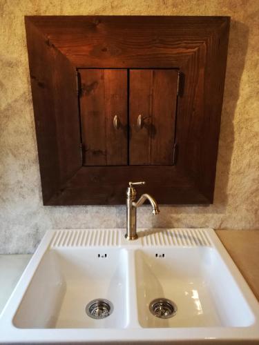 - un évier de cuisine avec une armoire en bois au-dessus dans l'établissement Momella House, à Colméry