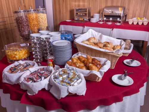 a table with baskets of bread and pastries on it at Hotel Miramar - São Pedro de Moel in São Pedro de Moel