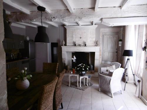 un salon avec une table et une cheminée dans l'établissement Clos des Morillons, à Vénérand