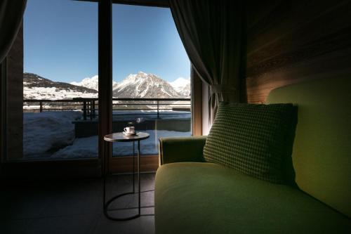 a room with a couch and a window with a mountain view at Chalet Heidi in Bormio